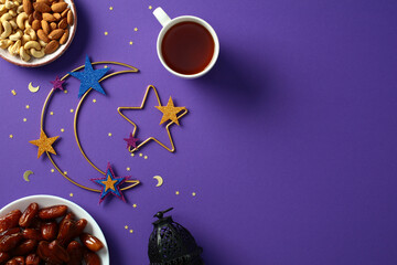 Ramadan celebration setup with tea, dates, nuts, and festive decorations on a purple background....