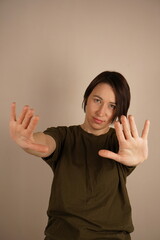Portrait of charming little girl with straight hair wearing green sweater and jeans stretching arms...