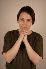 Photo portrait of beautiful girl - praying gesture looking for empty space, wearing fashionable...