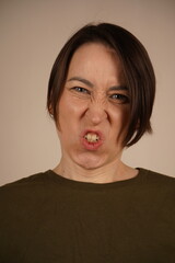 Brunette young woman standing over background disgusted expression, displeased and fearful doing...