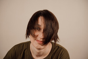 Cheerful mature woman with short brown hair in basic t-shirt smiling at camera isolated on white...