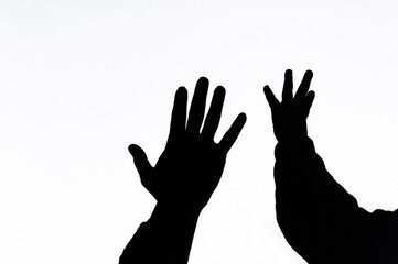 Shadow, silhouette from the hands of a child and woman mother, family on a white wall, background, showing love. Photography, gesturing concept, lifestyle.