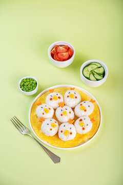 Naklejki Rice ball onigiri with filling in the form of chicken with funny faces in a plate