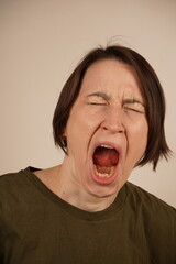 Brunette young woman standing over background disgusted expression, displeased and fearful doing disgust face because aversion reaction.