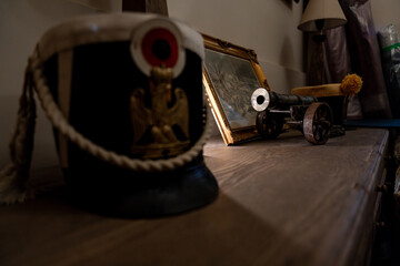 Obraz premium Canon miniature de l'époque napoléonienne accompagné d'un chapeau historique, représentant l'artillerie de l'époque.