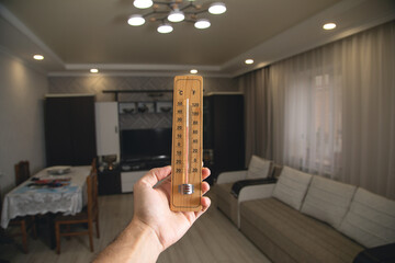 Male hand showing thermometer at room.