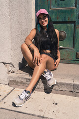 Young woman resting sitting on the threshold of a large old door.