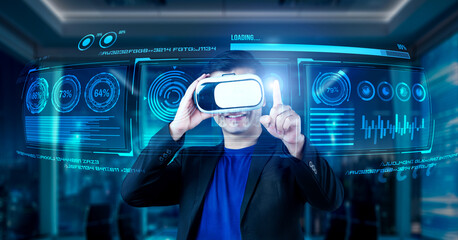 Project manager with VR goggles pointing financial chart and glowing blue light at office. Skilled businessman checking and planning marketing strategy by using data from augmented reality. Ingenuity.