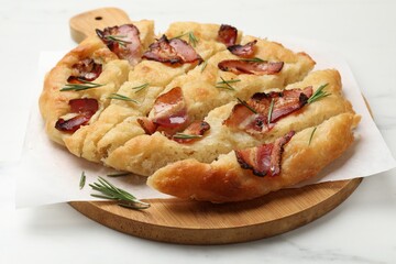 Slices of delicious focaccia bread with bacon and rosemary on white marble table, closeup