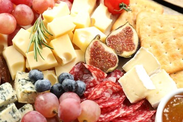 Different types of delicious cheese and other snacks as background, closeup