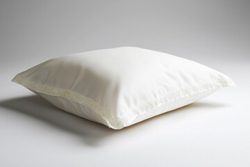 Soft white pillow with embroidered gold monogram elegant design displayed on pure white background