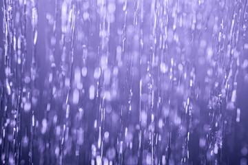 A detailed abstract shot of flowing water streams, illuminated with a serene blue tint, creating a calming and textured visual effect.