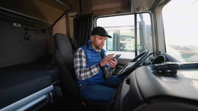 Truck driver reviews navigation on smartphone in cabin