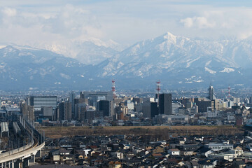 冬の富山市市街地中心部と北アルプス鍬崎山