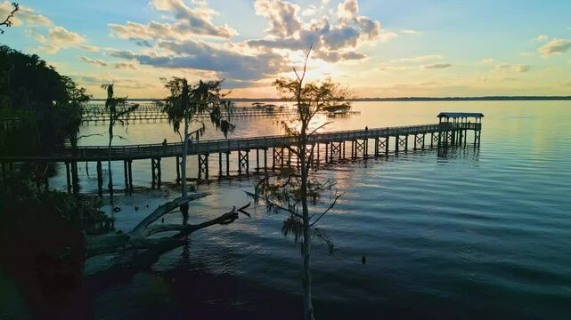 People on dock at sunset on the St. Johns River at Switzerland Point, Florida