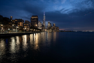 Obraz premium New York Skyline with One World Trade Center in the blue hour, light of the city reflecting in the water of hundson river