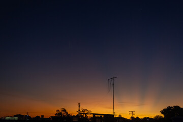 Twilight sky with silhouette of a tree and a power pole.