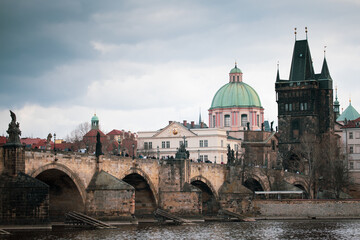 Old stone arched bridge against the backdrop of an old European town and tower
