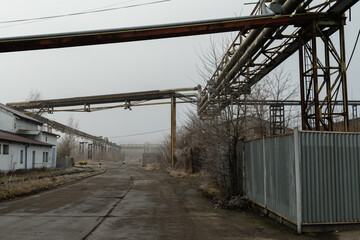 A road leading through an abandoned industrial area in winter fog
