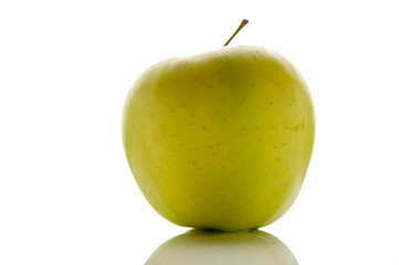 Fresh green apple sits elegantly on a reflective surface, showcasing its vibrant color and smooth texture
