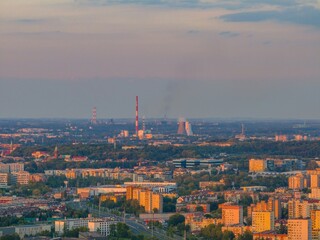 View of Krakow's skyline during sunset highlighting urban landscape and industrial structures in the distance