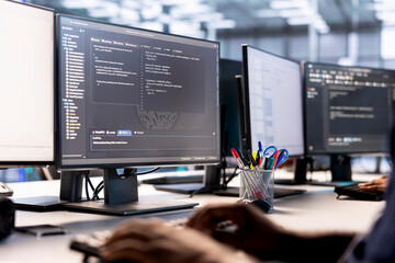 Data center technician using programming languages on PC to construct algorithms and build...