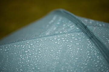 Water drops on waterproof green tent close up