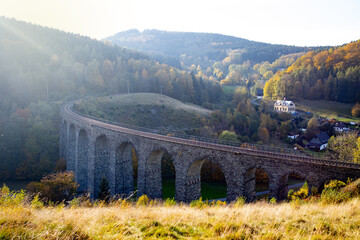 An ancient stone viaduct against the backdrop of autumn landscapes