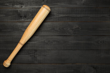 Wooden baseball bat on wooden background, top view