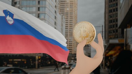 Golden bitcoin held by a hand with a waving Slovenia flag in the background against a modern urban...