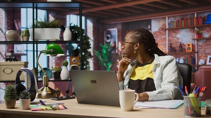 Remote employee pausing work done on laptop at home to pensive thinking. Teleworker in apartment feeling bored by repetitive tasks, stopping work on notebook to daydream, camera A