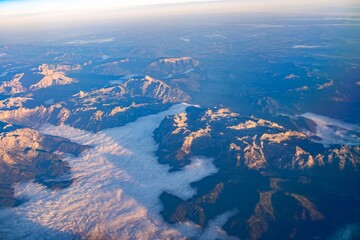 Stunning aerial view of majestic mountains and clouds during sunrise in a tranquil wilderness landscape