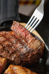 Assorted Cuts of Raw Meat with Knives, Charcoal, and Herbs on Rustic Background