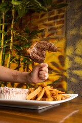 Assorted Cuts of Raw Meat with Knives, Charcoal, and Herbs on Rustic Background