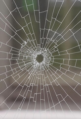Obraz premium Broken glass as spider web or as bullet hole in the door photography, black and white isolated background 