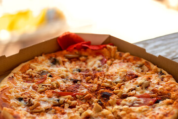 Baking background. Fragment of pizza with mushrooms in close-up. In cardboard box. Dishes of Italian cuisine.