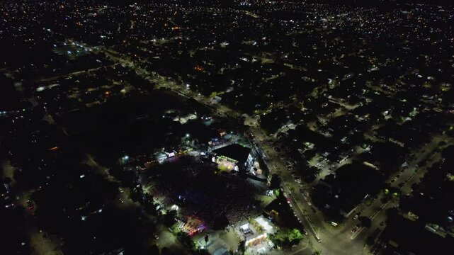 Dynamic Aerial View of a Live Concert with Crowded Stands and Cityscape Background