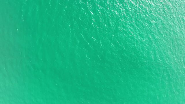 Top View of the sea surface background,Small waves crashing Foaming and Splashing in the Ocean. Sunny Day summer ocean sea background High quality footage 4-K 