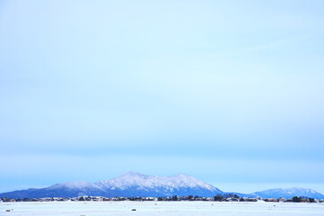 雪化粧した弥彦山と田園風景