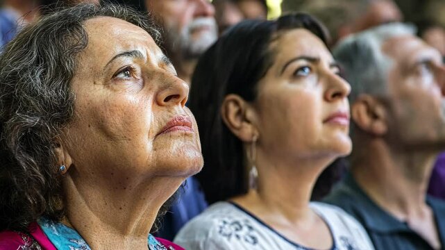 Audience engaged in deep contemplation during an emotional moment at a cultural event in a historic venue
