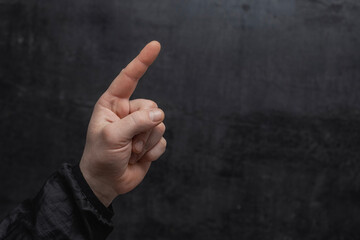Concept of pointing finger. Close-up of a man in a sweater pointing his finger forward against on...