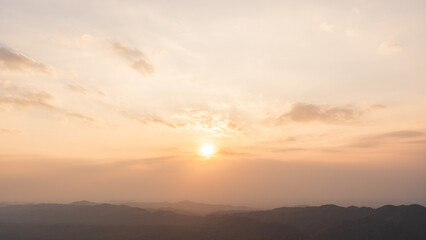 Sunset sky clouds in the Evening over mountain with golden hour orange, yellow sunlight sun dawn, Horizon landscape dusk sky background  