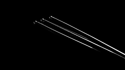 Three thin, metallic rods on black background.