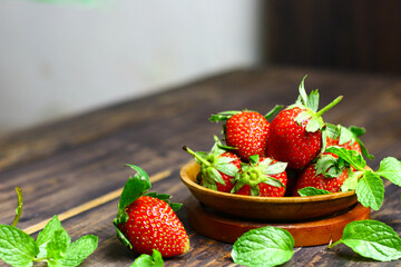 Fresh strawberry fruits and mint leaves on wooden  rustic background.