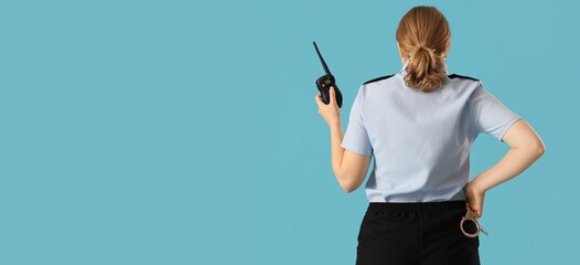 Female police officer holding walkie-talkie on light blue background with space for text, back view