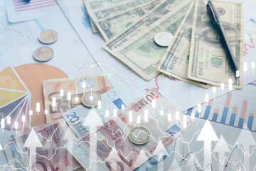 Different banknotes with coins and diagrams on virtual screen. Exchange rate concept