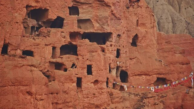 Ancient Dwelling Caves In Upper Mustang With Colorful Prayer Flags