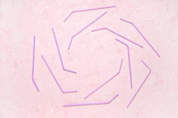 Frame made of many purple straws on grunge pink background