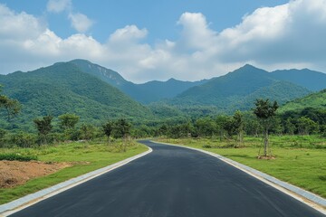 Naklejka premium Asphalt road curves gently through lush green landscape, mountains in the background. Perfect for travel, nature, and journey themes.