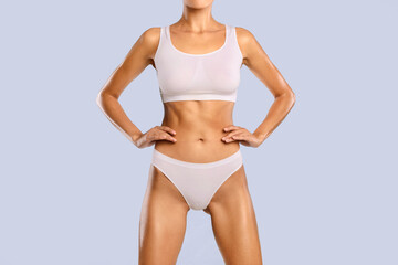 Closeup Cropped Frontal View Of Slim Lady With Perfect Body Shape And Flat Tummy Posing Holding Hands On Hips Isolated On Blue Studio Background, Woman Wearing White Lingerie. Fitness, Diet Concept